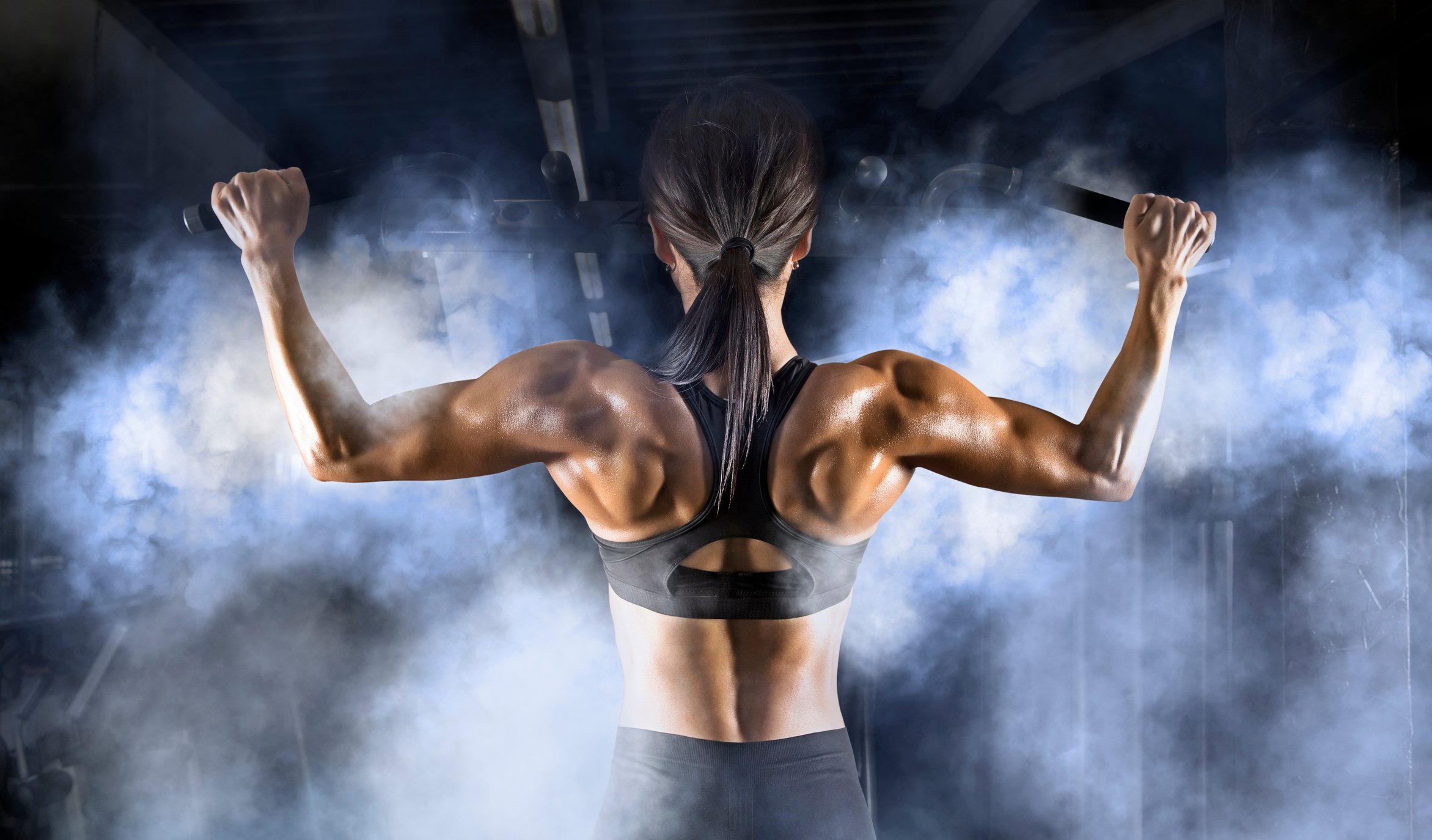 Muscular woman. Back training